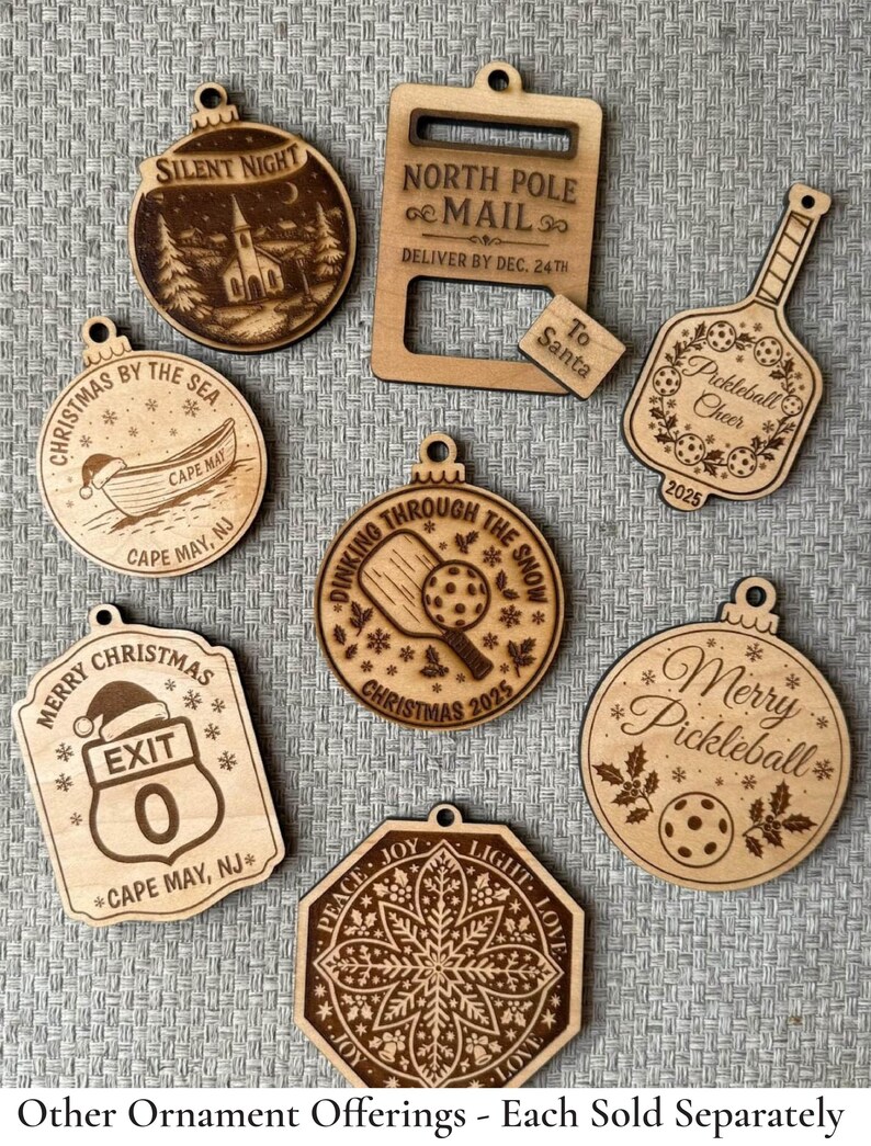 Puede incluir: Una colecci&oacute;n de adornos navide&ntilde;os de madera cortados con l&aacute;ser. Los dise&ntilde;os incluyen una escena de iglesia, un barco, una se&ntilde;al de tr&aacute;fico, una paleta de pickleball y un copo de nieve. Cada adorno tiene un agujero para colgar y presenta texto grabado.