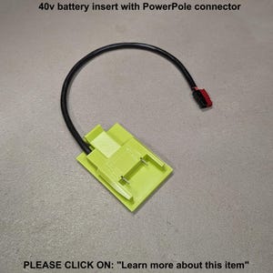 May include: A lime green 40v battery insert with a PowerPole connector. The insert has two metal prongs and a black cable that curves to the right. The text "40v battery insert with PowerPole connector" is above the insert. The text "PLEASE CLICK ON: "Learn more about this item"" is below the insert.