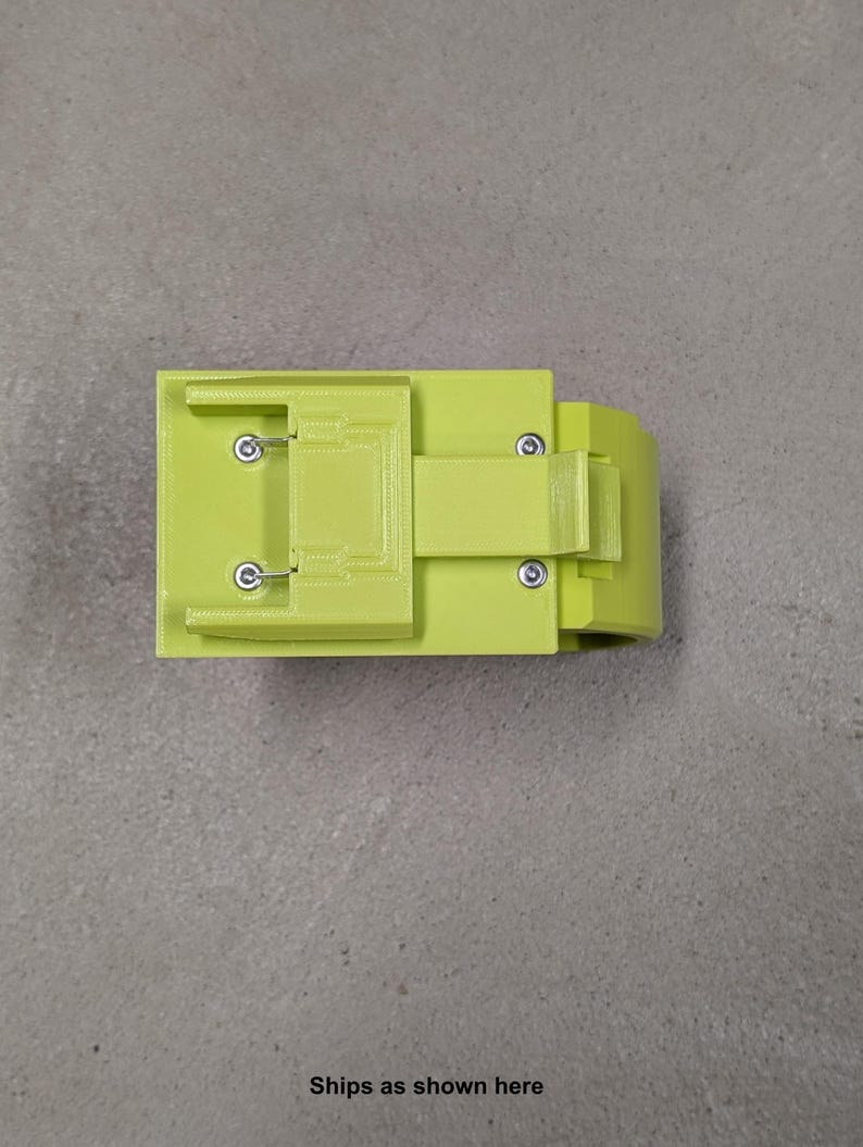 K&ouml;nnte beinhalten: Ein limegr&uuml;nes, 3D-gedrucktes Kunststoffteil mit rechteckiger Form und einem kleinen Griff. Das Teil hat mehrere kleine L&ouml;cher und einen Schlitz oben.