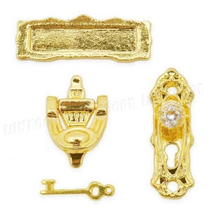 May include: A selection of miniature gold-coloured door hardware, including a rectangular sign, a door knocker, a key, and a decorative door handle with a crystal-like centre. The items have ornate detailing.
