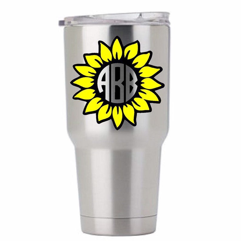 Puede incluir: Un vaso de acero inoxidable con un dise&ntilde;o de girasol amarillo y el monograma "ABB" en el centro.