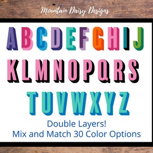 May include: A framed print featuring the alphabet in a colorful, 3D design. Each letter is a different color, with a shadow effect. The text "Double Layers! Mix and Match 30 Color Options" is also included.