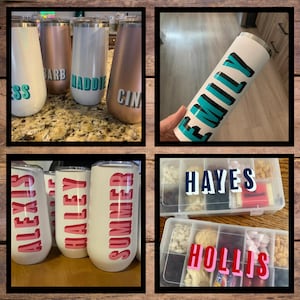 Op de afbeelding: Een verzameling gepersonaliseerde roestvrijstalen bekers en een snackbox. De bekers zijn in verschillende kleuren, waaronder wit, ros&eacute;goud en zilver, elk met een naam in vette letters. De snackbox is verdeeld in compartimenten met namen.