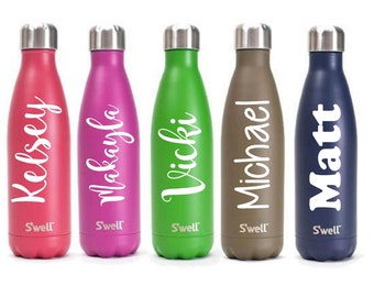 May include: Five stainless steel water bottles with personalized names in white lettering. The bottles are in various colors: pink, purple, green, brown, and blue. Each bottle has the word "S'well" printed on the bottom.
