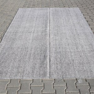 May include: A gray and white area rug with a subtle textured pattern. The rug is rectangular and has a center seam.