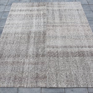 May include: A light gray area rug with a subtle, textured pattern. The rug has a slightly distressed look, giving it a vintage feel.