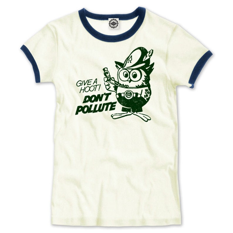 May include: A white t-shirt with a blue ringer neck. The shirt features a green cartoon owl wearing a hat and holding a sign that says "Give a Hoot! Don't Pollute".