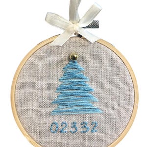 Puede incluir: Una taza de cerámica blanca con un asa negra y el texto "But First, Coffee" en negrita negra. La taza está sobre una superficie de madera. La taza mide 10 cm de alto.