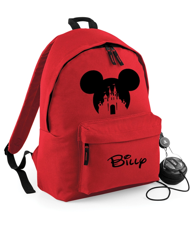 May include: Red backpack with a black Mickey Mouse silhouette with a castle inside the ears. The backpack has a black zipper and a black pocket on the front. The name "Billy" is written in black on the front pocket.