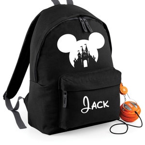 May include: Black backpack with a white silhouette of Mickey Mouse ears and a castle inside the ears. The backpack has a front pocket with the name "Jack" written in white.