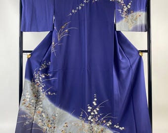 May include: A traditional Japanese kimono with a blue background and a white floral pattern. The kimono is displayed on a stand.
