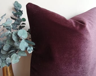 May include: A deep purple velvet pillow with a soft, plush texture. The pillow is shown against a white background.