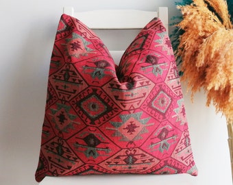 May include: A red and grey patterned cushion with a geometric design. The cushion is made of a soft, woven fabric and has a subtle sheen.