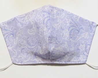 May include: A white face mask with a light purple paisley pattern.