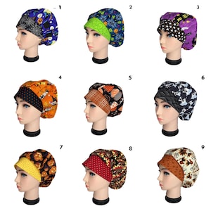 May include: A collection of nine Halloween-themed scrub caps. Each cap features a different pattern, including bats, pumpkins, ghosts, and spiderwebs. The caps are made of fabric and have a visor.