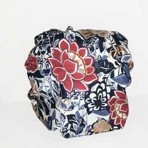 Puede incluir: Un gorro para el cabello con estampado floral que presenta una gran flor roja con detalles blancos y amarillos. El gorro tiene un dise&ntilde;o floral azul marino, blanco y azul claro. El gorro est&aacute; dise&ntilde;ado para proteger el cabello.