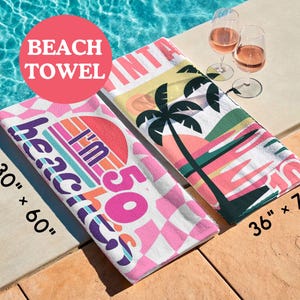 Pu&ograve; includere: Due teli mare rettangolari con grafiche in stile retr&ograve;. Uno misura 76 cm per 152 cm e presenta un motivo a scacchi rosa con il testo I'm 50 beaches. L'altro misura 91 cm per 183 cm e mostra palme e un disegno di un tramonto.