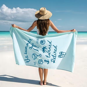 Pu&ograve; includere: Un telo mare azzurro con grafiche blu scuro raffiguranti un calice di vino, una conchiglia, una palma, infradito e un nastro. Il testo recita: the summer est. 2026 I turned Retired. L'asciugamano &egrave; rettangolare e realizzato in tessuto morbido.