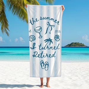 Pu&ograve; includere: Un telo mare a righe bianche e azzurre con la scritta blu scuro "the summer est. 2026 I turned Retired" e illustrazioni grafiche di un bicchiere da cocktail, un fiocco, conchiglie, una palma e un paio di infradito.