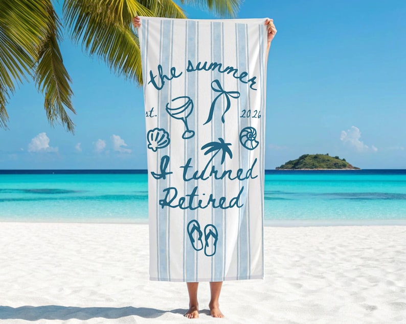 Pu&ograve; includere: Un telo mare a righe bianche e azzurre con la scritta blu scuro "the summer est. 2026 I turned Retired" e illustrazioni grafiche di un bicchiere da cocktail, un fiocco, conchiglie, una palma e un paio di infradito.