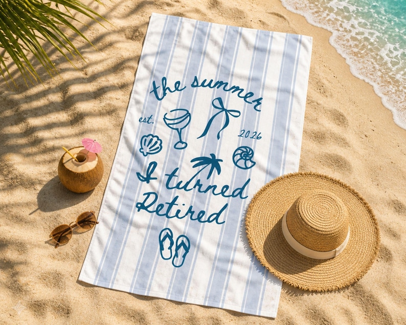Pu&ograve; includere: Un telo mare rettangolare con strisce verticali azzurre e bianche. Al centro presenta una scritta blu scuro che recita the summer est. 2026 I turned Retired, accompagnata da icone grafiche di un bicchiere da cocktail, un fiocco, conchiglie, una palma e infradito.