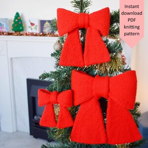 May include: A decorated Christmas tree featuring three large, red, knitted bows. The bows vary in size and provide a festive appearance. The image also includes text that says "Instant download PDF knitting pattern".