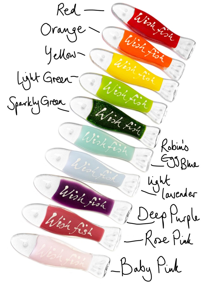 May include: A set of ten glass wish fish ornaments in various colors, including red, orange, yellow, green, blue, purple, and pink. Each fish has the words "Wish Fish" written on it.