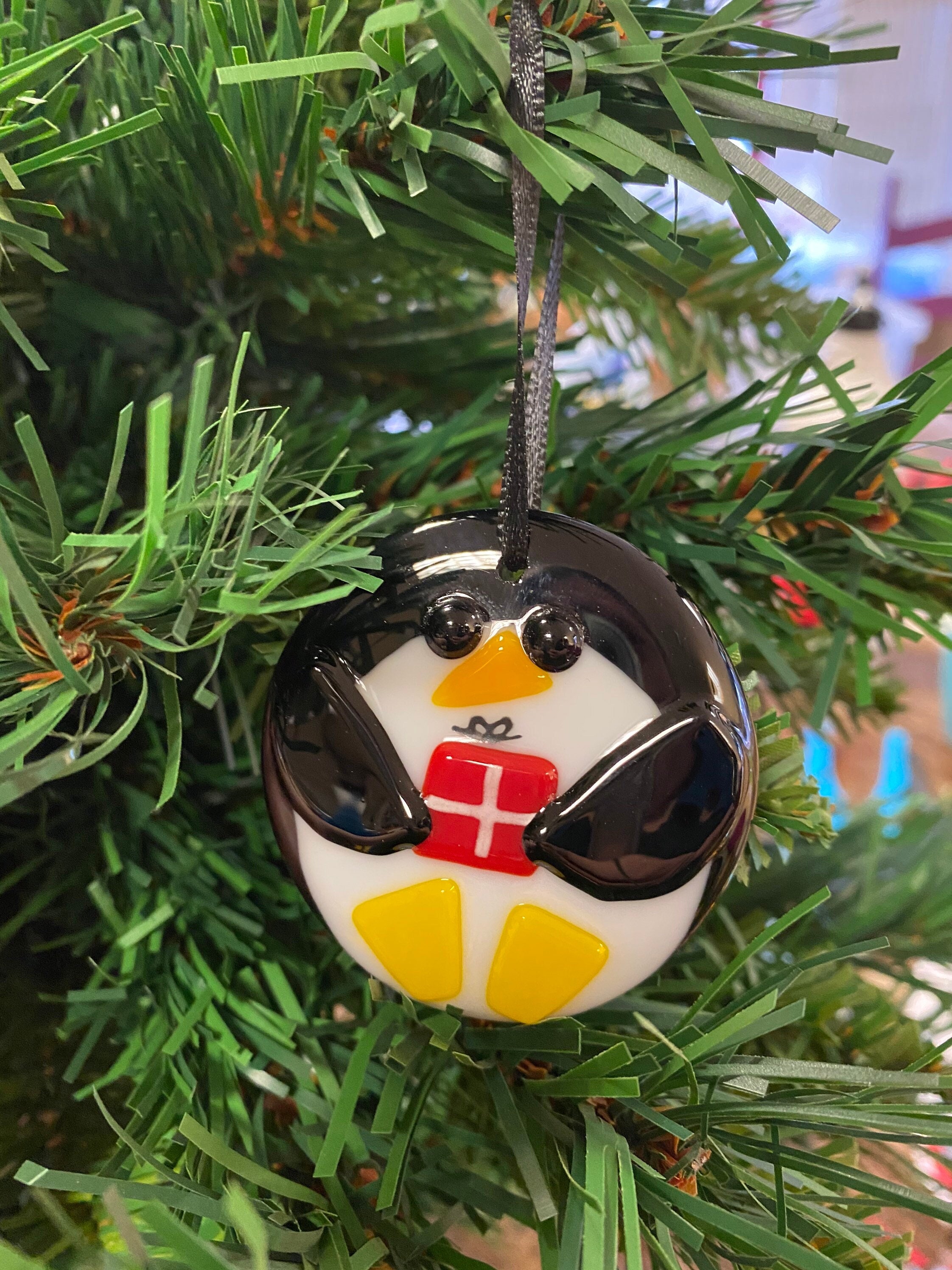 Niedlicher Pinguin mit Geschenk in Schneekuppel Glas