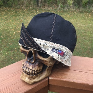 Może przedstawiać: Czarna czapka spawalnicza z wzorem bandany w kolorze brązowym i białym. Bandana ma małą flagę amerykańską z napisem "Made in USA".