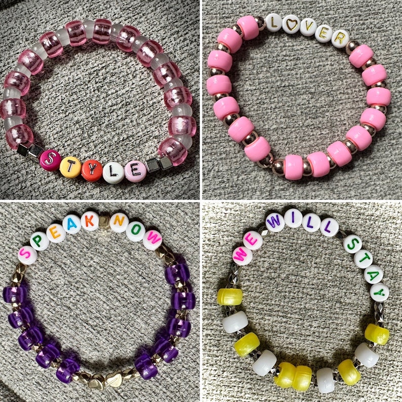 May include: Four colorful beaded bracelets with different words spelled out on them. The bracelets are pink, purple, and yellow. The words on the bracelets are "STYLE", "LOVER", "SPEAK NOW", and "WE WILL STAY".