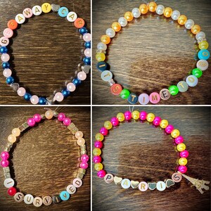 May include: Four colorful beaded bracelets with gold lettering spelling out the phrases "Get Away Car", "It's Time To Go", "I Survived", and "Paris".
