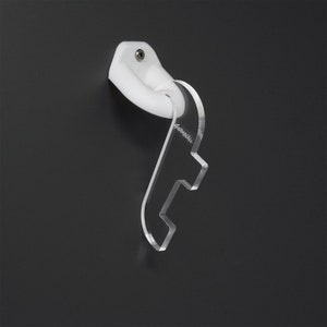 May include: White plastic wall mount with a clear acrylic guitar hook. The hook is shaped like a guitar headstock with a small notch for the guitar's headstock.