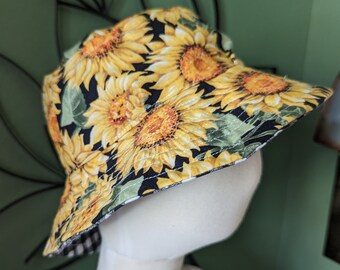 May include: A black bucket hat with a sunflower print. The hat has a black and white checkered lining.