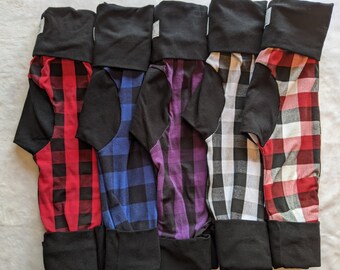 May include: Five pairs of black and white plaid leggings with black fold-over cuffs. The leggings are in red, blue, purple, white, and red.