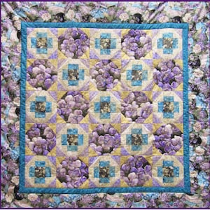 May include: A quilt with a purple floral pattern, a blue and yellow geometric design, and a border of purple flowers.