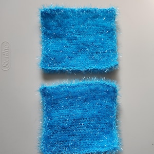 May include: Two blue knitted dishcloths with a fuzzy texture. The dishcloths are made of a sparkly yarn.