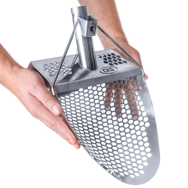May include: A silver metal scoop with a honeycomb-shaped mesh and a handle. The scoop is held by a hand and the brand name "CKG" is visible on the scoop.