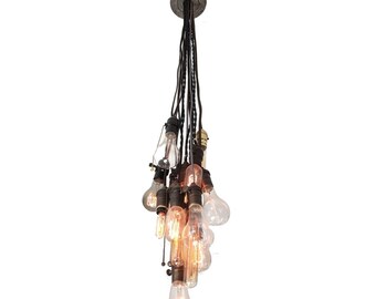 Puede incluir: Un grupo de bombillas de estilo vintage cuelgan de un cable negro, creando una lámpara de araña única de inspiración industrial.