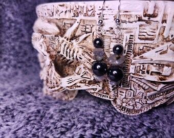 May include: A pair of silver dangle earrings with black hematite beads and iridescent labradorite stones.