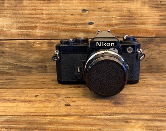 Hermosa cámara de película manual Nikon FE de cuerpo negro con Nikon 50 mm f1.8