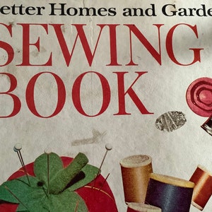 May include: A vintage Better Homes and Gardens Sewing Book with a red title and illustrations of sewing supplies, including a pincushion, spools of thread, and a thimble.