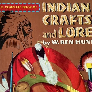May include: The Complete Book of Indian Crafts and Lore by W. Ben Hunt. The cover features a black and white illustration of a Native American man wearing a feathered headdress. The background is brown with a red, white, and green illustration of a Native American headdress.