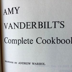 May include: A book titled "AMY VANDERBILT'S Complete Cookbook" with the words "DRAWINGS BY ANDREW WARHOL" printed below the title.
