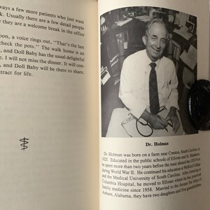 Op de afbeelding: Zwart-witfoto van een dokter die een wit overhemd en een donkere das draagt. Hij houdt een stethoscoop in zijn handen. De foto is afkomstig uit een boek over het leven van een dokter. De tekst onder de foto luidt "Dr. Holman".