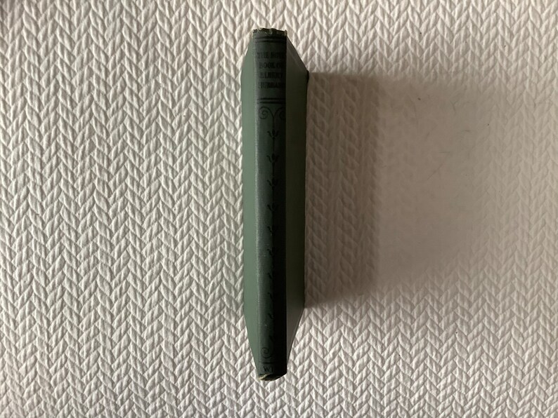 May include: A small, green hardcover book with the title "The Book of the Little  Green  Men" printed on the spine.