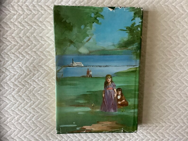 May include: A vintage book cover with a green, blue, and brown illustration of two girls standing in a grassy field. The girls are wearing dresses and are looking at the viewer. In the background, there is a lake and a boat.