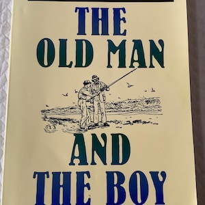 May include: A book cover with the title "THE OLD MAN AND THE BOY" in blue and green lettering. An illustration depicts two figures fishing on a beach, with seagulls overhead. The background is a light yellow color.