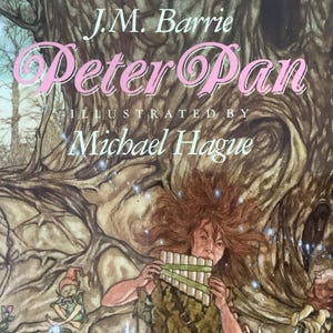 May include: A book cover for "Peter Pan" by J.M. Barrie, illustrated by Michael Hague. The title is in pink script, with a detailed illustration of a character playing a pan flute, set against a backdrop of a large tree and forest.