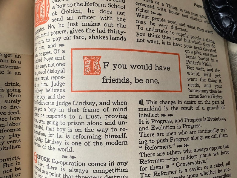 May include: A black and white image of a book page with text that reads "If you would have friends, be one." The text is in a bold, serif font and is surrounded by a decorative border.