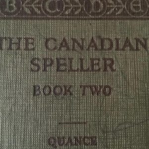 May include: Close-up of a vintage book cover. The cover is a textured olive green with the title "THE CANADIAN SPELLER" in dark brown lettering. Below the title, it reads "BOOK TWO". The book has an ornate border.